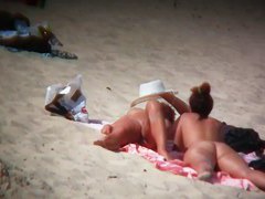 Nude sun tanning girls expose themselves to a beach spy cam