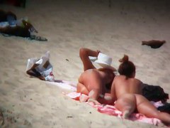 Nude sun tanning girls expose themselves to a beach spy cam