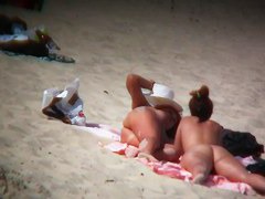 Nude sun tanning girls expose themselves to a beach spy cam