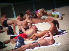 Voyeur on the beach capturing a tanned and naked girl