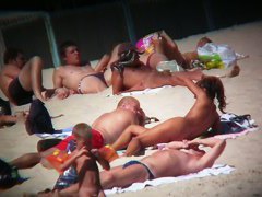 Voyeur on the beach capturing a tanned and naked girl