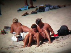 Voyeur on the beach capturing a tanned and naked girl