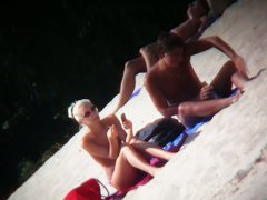 A couple sizzling hot blondes tanning in a nudist beach porno