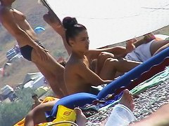 Hot red hair babe takes a nude sunbath at the beach