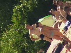 Hot brunette bares it all to the nudist beach voyeur