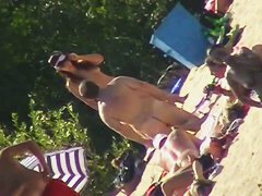 Hot brunette bares it all to the nudist beach voyeur