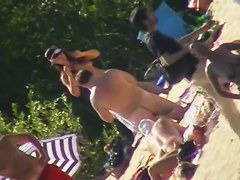 Hot brunette bares it all to the nudist beach voyeur