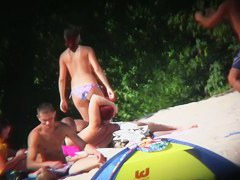 Nudist beach with dressed gentlemen and topless ladies