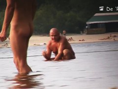 Sun warming up bodies of beach nudist girls and men