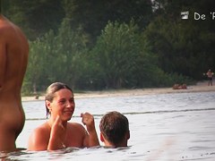 Sun warming up bodies of beach nudist girls and men