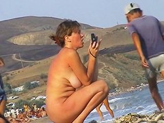 Sexy beach nudist girl spied talking on phone near water