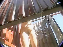 Femme brune se rase les poils dans une cabine de plage