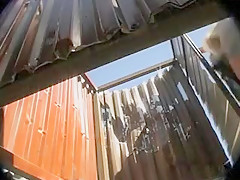 Femme brune se rase les poils dans une cabine de plage