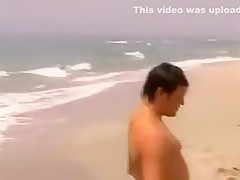 Un couple baise sur une plage par une journée ventée