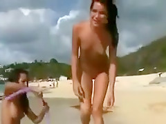 Trois jeunes lesbiennes se touchent sur la plage