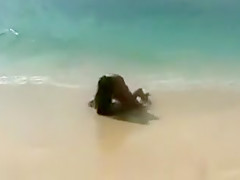 Trois jeunes lesbiennes se touchent sur la plage