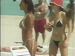De belles femmes en bikini ou topless sur le sable fin
