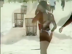 De belles femmes en bikini ou topless sur le sable fin