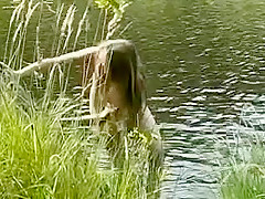 Une russe naturiste bronze nue au bord d'un lac