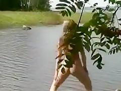 Une russe naturiste bronze nue au bord d'un lac