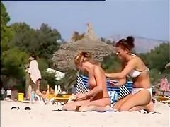 Deux copines topless simulent de baiser sur la plage