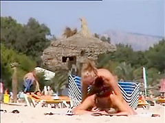 Deux copines topless simulent de baiser sur la plage