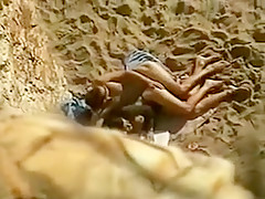 Mec baise sa femme sur une plage en essayant de se cacher