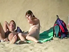Belle nana à forte poitrine filmée pendant une branlette à la plage