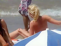 Jeune blonde aux seins qui pointent sur la plage