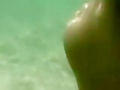 Asiatique aux mamelles volumineuses se trouve nue sur la plage