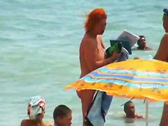 Buxom nude beach babes flaunt their jugs before a hidden camera