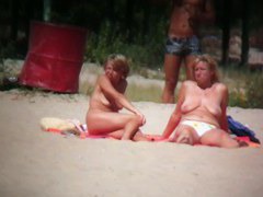 Brunette cutie with a perky butt filmed on a nudist beach