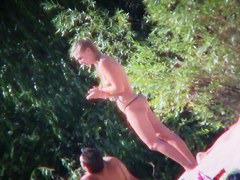 Two brunettes and one blonde on a nudist beach tanning and bending