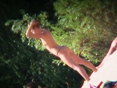 Two brunettes and one blonde on a nudist beach tanning and bending