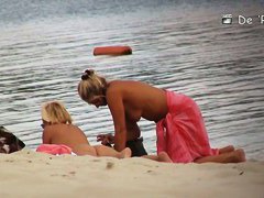 Voyeur spies on a perky breasted MILF on a nudist beach