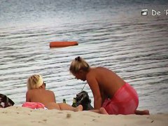 Voyeur spies on a perky breasted MILF on a nudist beach