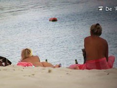 Voyeur spies on a perky breasted MILF on a nudist beach