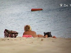 Voyeur spies on a perky breasted MILF on a nudist beach