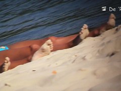 Beach voyeur man enjoys the view of topless female tits
