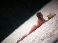Hot body babe lying down on the beach surprised by a spy cam