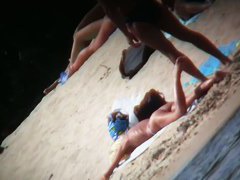 A voyeur is hunting for beautiful women on a nudist beach