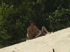Couple taking sunbaths and walking nakes on the beach