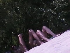 Couple taking sunbaths and walking nakes on the beach