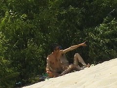 Couple taking sunbaths and walking nakes on the beach