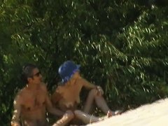 Couple taking sunbaths and walking nakes on the beach