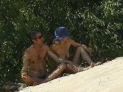 Couple taking sunbaths and walking nakes on the beach