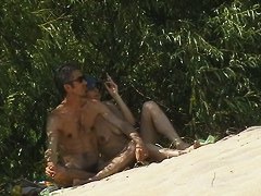 Couple taking sunbaths and walking nakes on the beach
