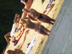Mature women with big butts taking sunbaths on the beach