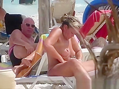 Milf topless woman creams on the beach