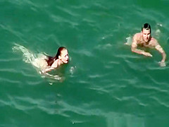 Nudist redhead swimming in the water